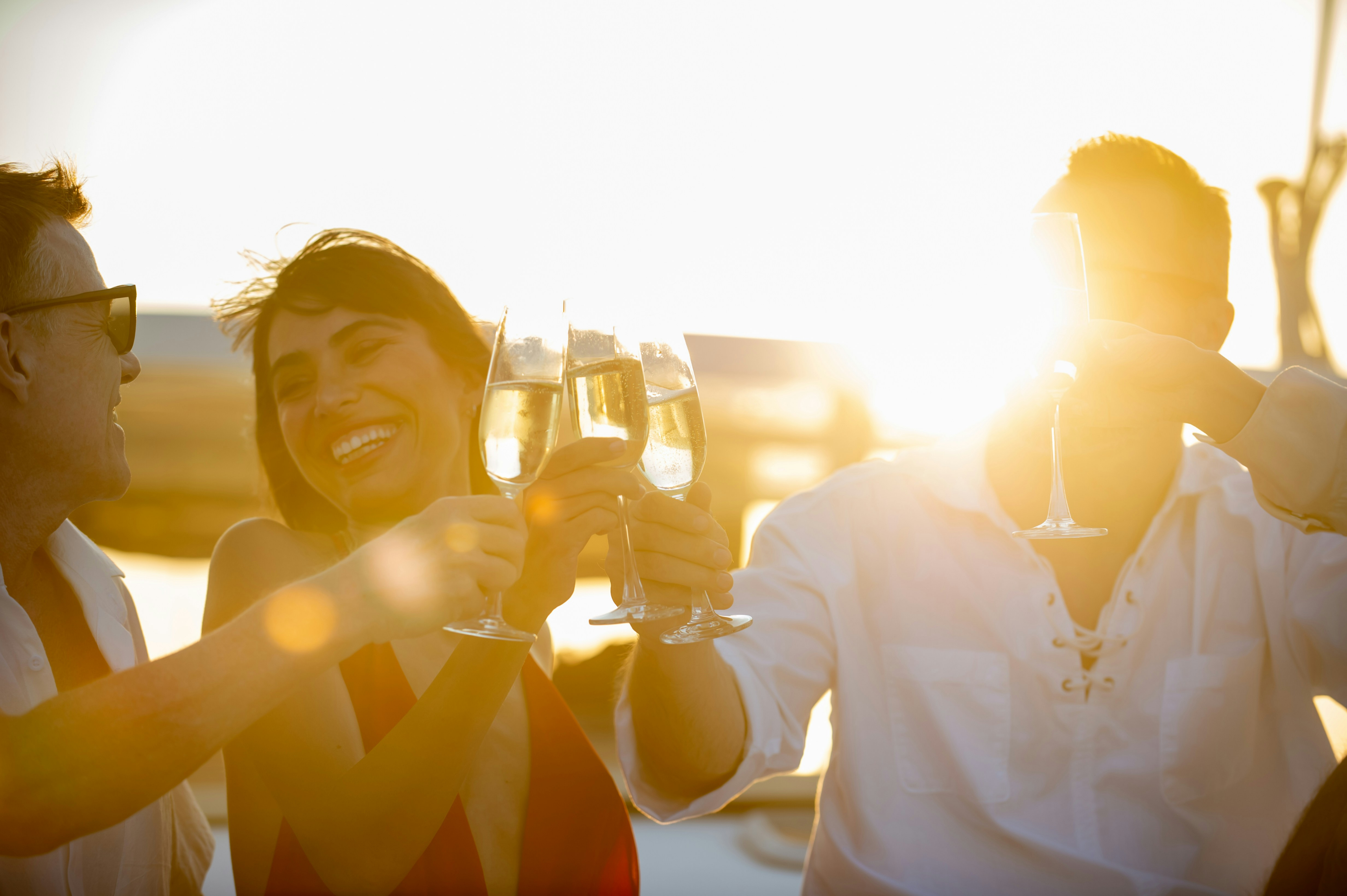 Friends toasting champagne glasses at sunset