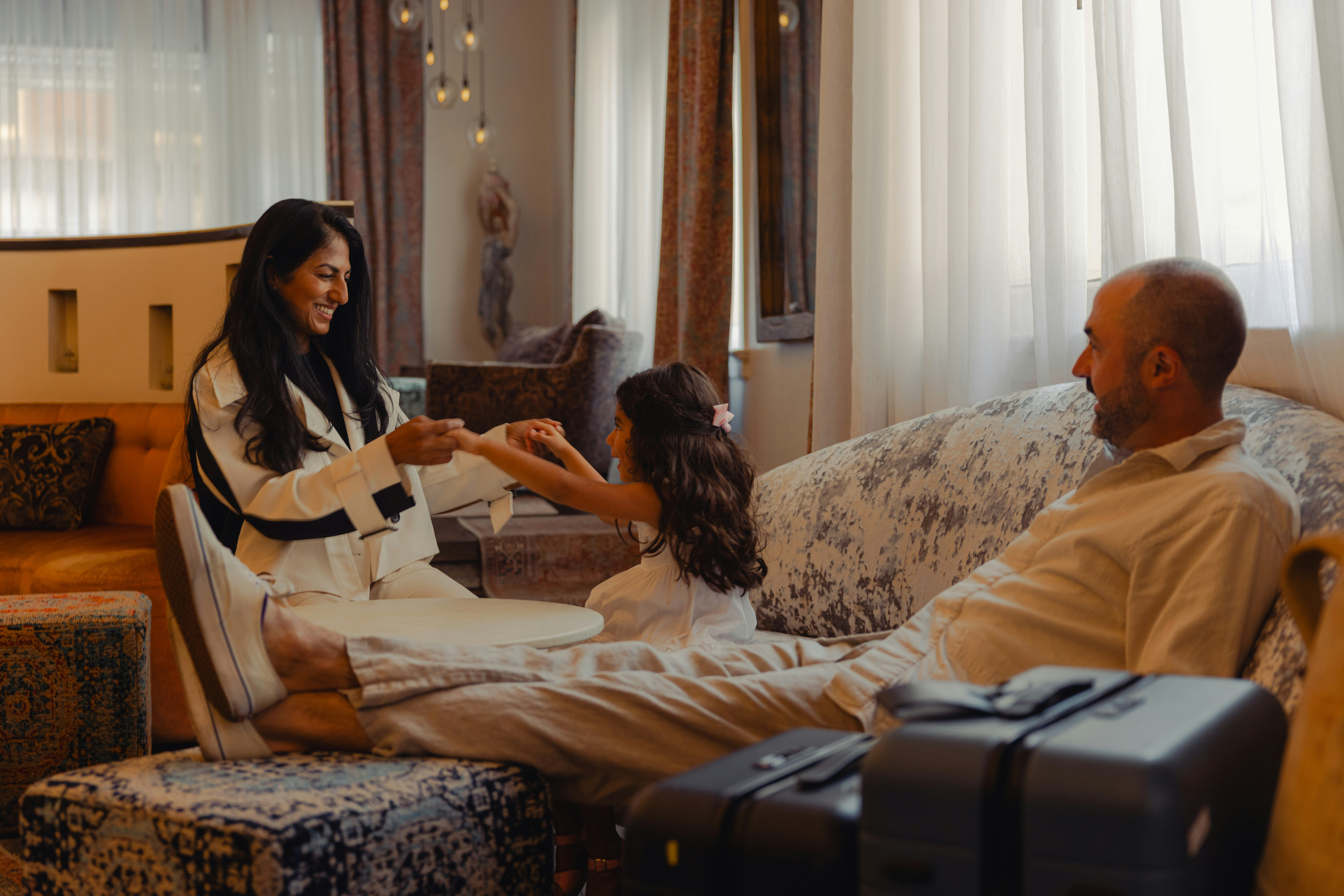 Family enjoying tea and laughter in a cozy hotel suite