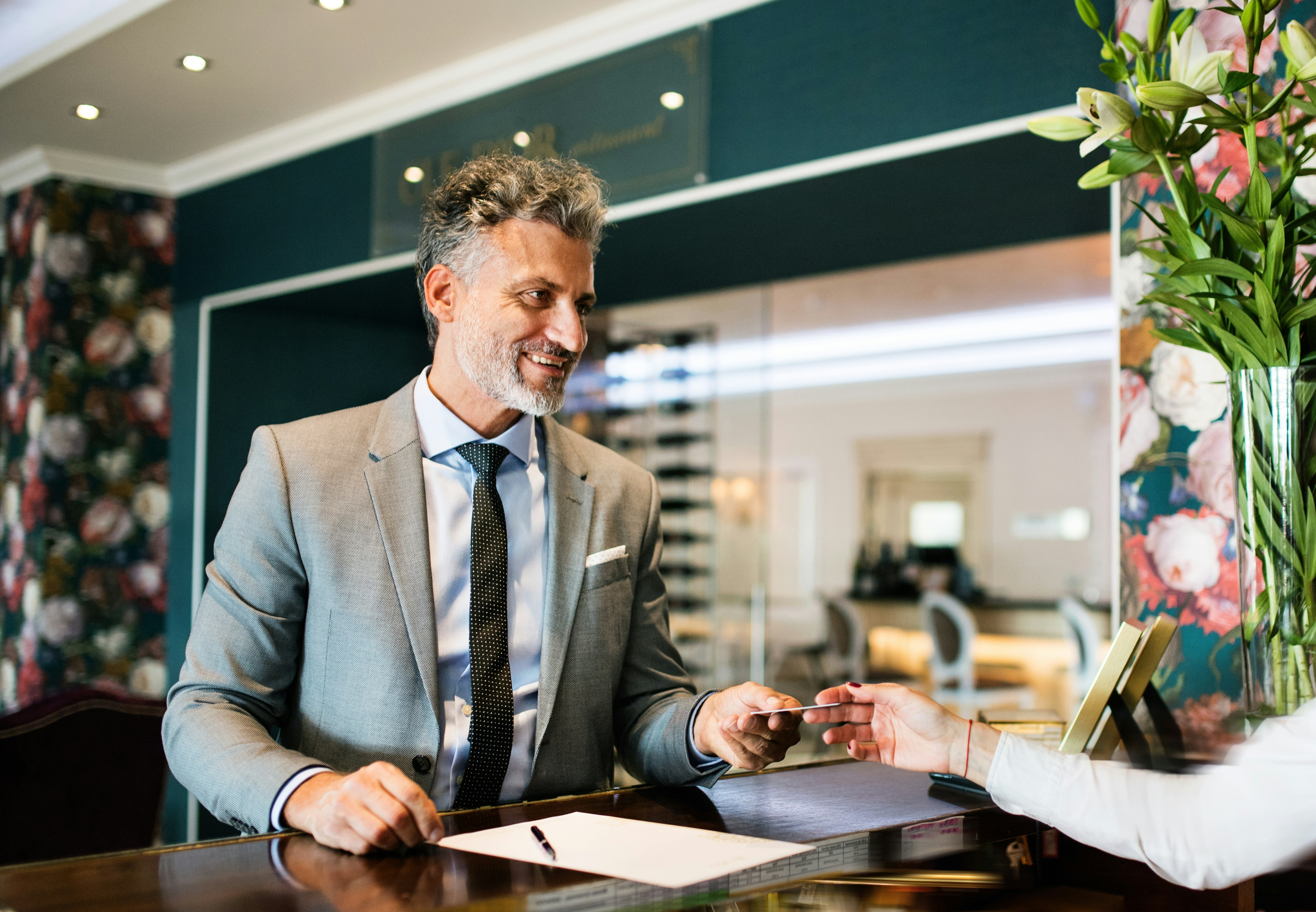 Hotel concierge handing a key card to a guest at the reception desk