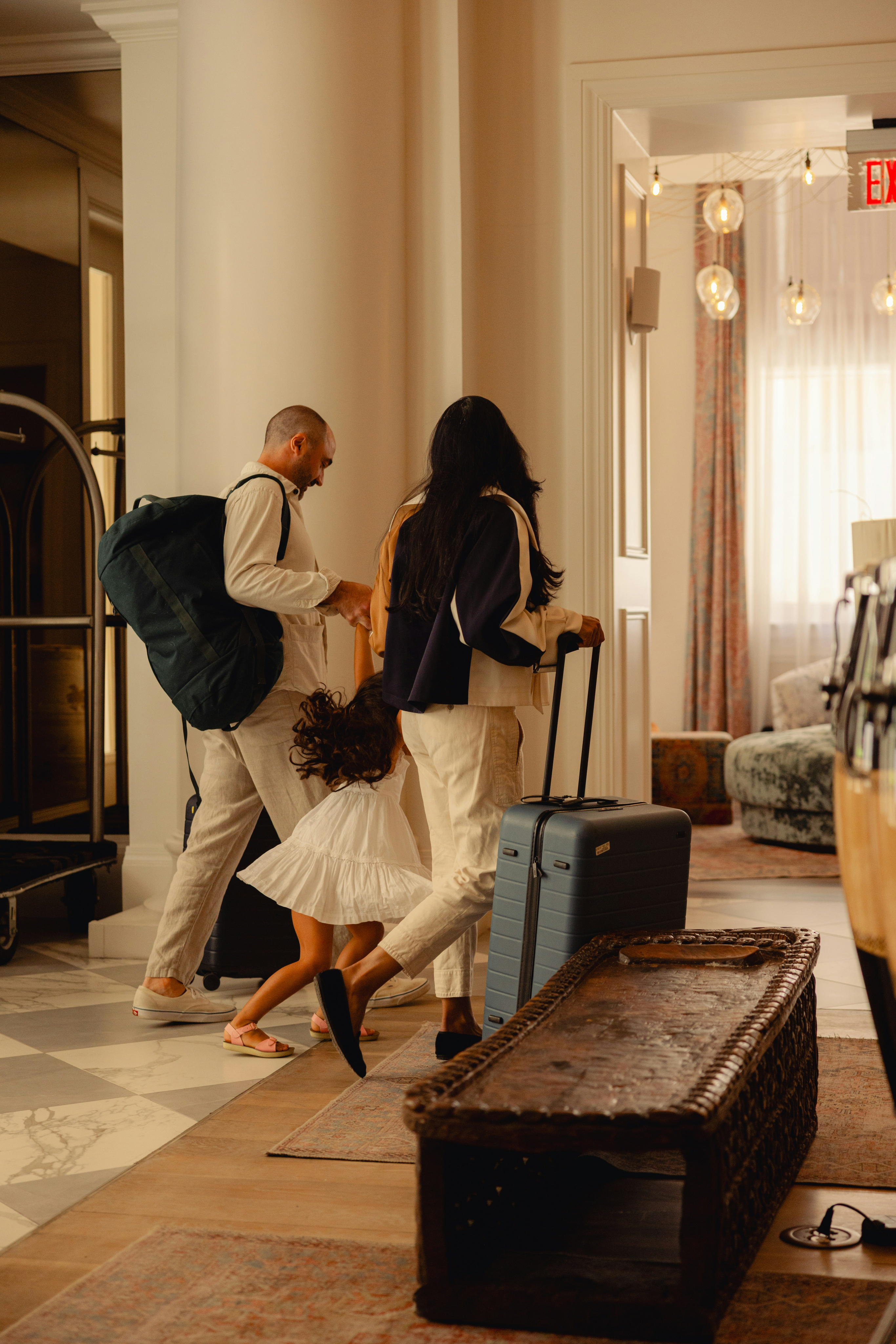 Family checking into a hotel, greeting staff with smiles and luggage